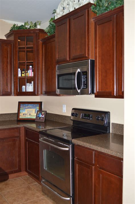 stainless steel appliances with mahogany cabinets|appliances and cabinets in kitchen.